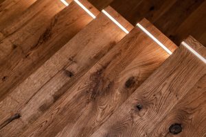 Modern Residential Dark Wooden Stairs with LED Illumination Close Up Photo. Stairs Light.
